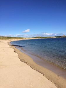 a beach with the ocean and the shoreline at 2 The Noust Self Catering in Saint Margarets Hope