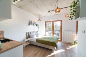 a bedroom with a bed with a green blanket at Silver Forest in Szczecin