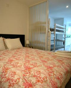 um quarto com uma cama grande e uma colcha floral em The Sun House em Santa Iria de Azóia