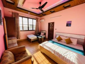 ein Schlafzimmer mit einem Bett und einem Sofa in einem Zimmer in der Unterkunft Karachi Inn in Karatschi