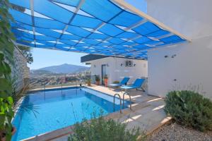 a swimming pool with a blue canopy over a house at Villa Sheyma in Kalkan