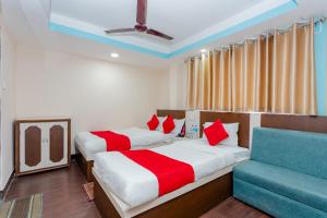 a bedroom with two beds and a blue couch at OYO 811 Hotel New Pokhara Palace in Kathmandu