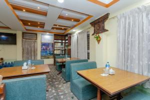 a dining room with blue chairs and tables at OYO 811 Hotel New Pokhara Palace in Kathmandu