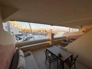 a balcony with a table and chairs and a marina at Piso islas C111 in Benalmádena