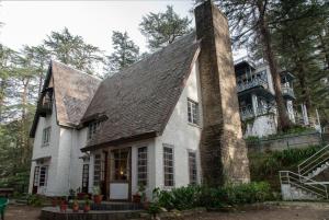 uma grande casa branca com uma chaminé em cima em Shimla British Resort em Shimla