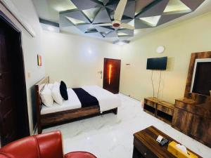 a bedroom with a bed and a tv and a couch at Karachi Inn in Karachi