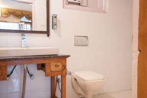 Shimla British Resort في شيملا: حمام به مرحاض أبيض ومغسلة