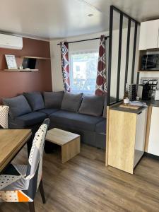a living room with a couch and a table at SOLEIL & PLAGE au CAMPING MAR ESTANG 4 ETOILES in Canet-en-Roussillon