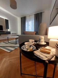ein Wohnzimmer mit einem Tisch und einem Sofa in der Unterkunft Dalmatinska apartment in Belgrad
