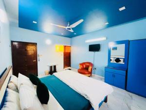 a blue bedroom with a bed and a chair at Karachi Inn in Karachi