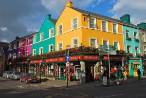 a colorful building on a street with cars parked in front at Quills Townhouse Kenmare in Kenmare