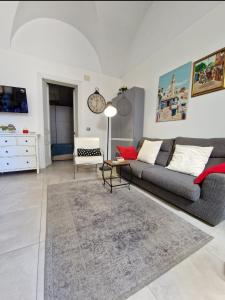 a living room with a gray couch and a rug at Elvira Home in Catania +12 photos