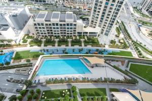 een uitzicht op een groot gebouw met een zwembad bij 2bdr - Pool - Emaar - Creek Harbour in Dubai