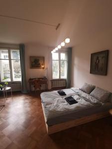 Schlafzimmer mit einem Bett, einem Tisch und Fenstern in der Unterkunft Beautiful central Apartment in Bern