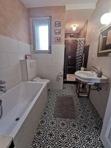 y baño con bañera, lavamanos y bañera. en Beautiful central Apartment en Berna