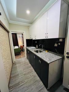a kitchen with black and white cabinets and a sink at LALE SULTAN SÜİT APART in Istanbul
