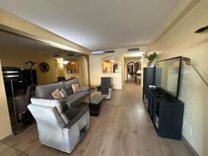 a living room with a couch and a television at Piso islas C111 in Benalmádena