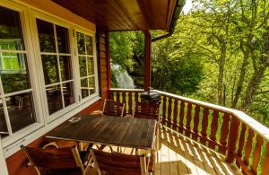 a porch with a wooden table and chairs on it at FOSSEN CAMPING in Geiranger