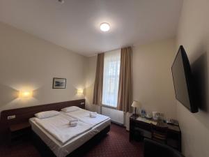 a hotel room with a bed and a television at Memel Hotel in Klaipėda