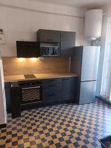 a kitchen with a stove and a refrigerator at Légèreté aux Mûriers in Le Lavandou