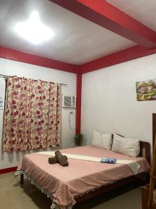 Schlafzimmer mit einem Bett mit roter Decke in der Unterkunft Friendly Transient House in Puerto Princesa