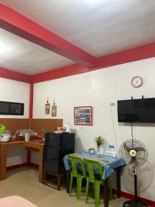Zimmer mit einem Tisch und einem Schreibtisch mit einem Ventilator in der Unterkunft Friendly Transient House in Puerto Princesa