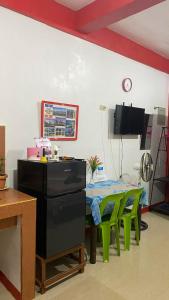 ein Esszimmer mit einem Tisch und grünen Stühlen in der Unterkunft Friendly Transient House in Puerto Princesa