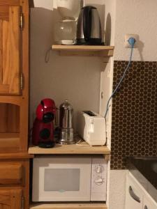 a kitchen with a counter with a microwave at plein sud in Saint-Aventin