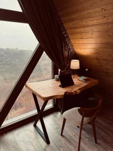 a desk with a laptop on it in a room with a window at SweeDom Shale in Almaty