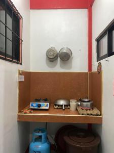 eine Küche mit zwei Töpfen und Pfannen auf einem Regal in der Unterkunft Friendly Transient House in Puerto Princesa