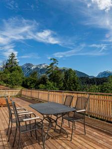 einen Tisch und Stühle auf einer Holzterrasse mit Bergen in der Unterkunft Gasthaus Rössli in Versam