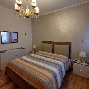 a bedroom with a large bed and a chandelier at NSM La Vie en Rose appartamento con box e terrazzo in Foggia