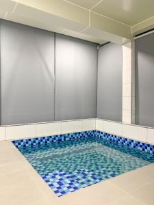 a swimming pool with blue tiles in a room at 365 Homestay in Kaki Bukit