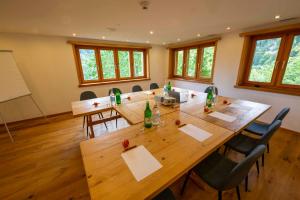 a conference room with a large wooden table and chairs at Gasthaus Rössli in Versam