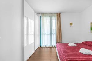 sypialnia z czerwonym łóżkiem i 2 ręcznikami w obiekcie Vacation paradise at Lake Iseo w mieście Iseo