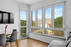 a living room with windows and a table and chairs at Sylvia Center Apartment in Pula