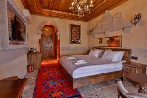 una camera con un grande letto e un tavolo di Chiaro Boutique Hotel a Üçhisar
