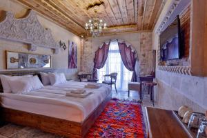 a bedroom with a large bed and a chandelier at Chiaro Boutique Hotel in Uchisar