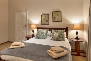 a bedroom with a bed with towels on it at Auldstone House in Dullstroom