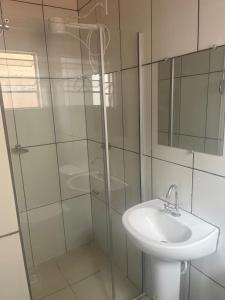 a bathroom with a sink and a glass shower at H POUSADA DO BENTO in Aparecida