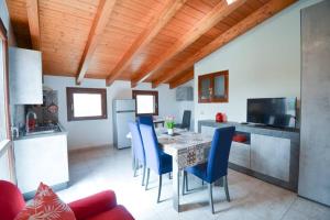 a kitchen with a table and blue chairs at [NEW] (SANT'ANTIOCO) Appartamento moderno a due passi dal centro in SantʼAntìoco