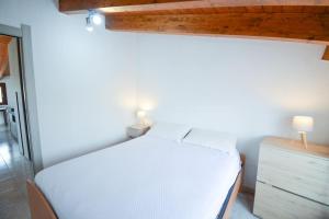 a bedroom with a white bed and a wooden ceiling at [NEW] (SANT'ANTIOCO) Appartamento moderno a due passi dal centro in SantʼAntìoco