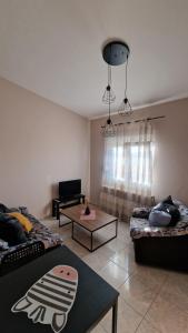Sala de estar con 2 camas y mesa en Kofinaki apartment 1, en Tycherón