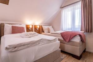 two twin beds in a room with a window at Lipno Village Houses in Frymburk