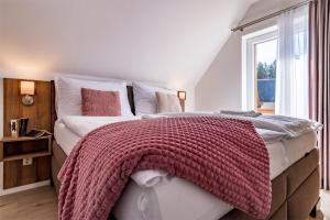 a bedroom with a large bed with a blanket on it at Lipno Village Houses in Frymburk