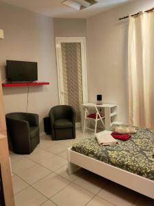 トリエステにあるAffittacamere Guerrero Roomsのベッドルーム1室(ベッド1台、椅子2脚、テレビ付)