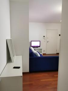 a living room with a blue couch and a tv at Affittacamere Guerrero Rooms in Trieste