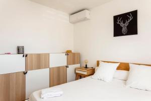 a bedroom with two beds with white pillows at Chez Morgane - Superbe maison familiale proche des remparts in Aigues-Mortes