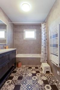 uma casa de banho com uma banheira, um lavatório e um chuveiro em Chez Morgane - Superbe maison familiale proche des remparts em Aigues-Mortes