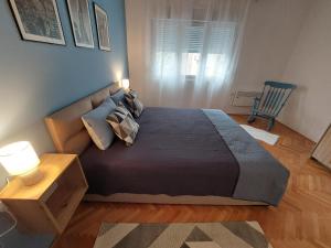ein Schlafzimmer mit einem Bett, einem Tisch und einem Stuhl in der Unterkunft Dalmatinska apartment in Belgrad
